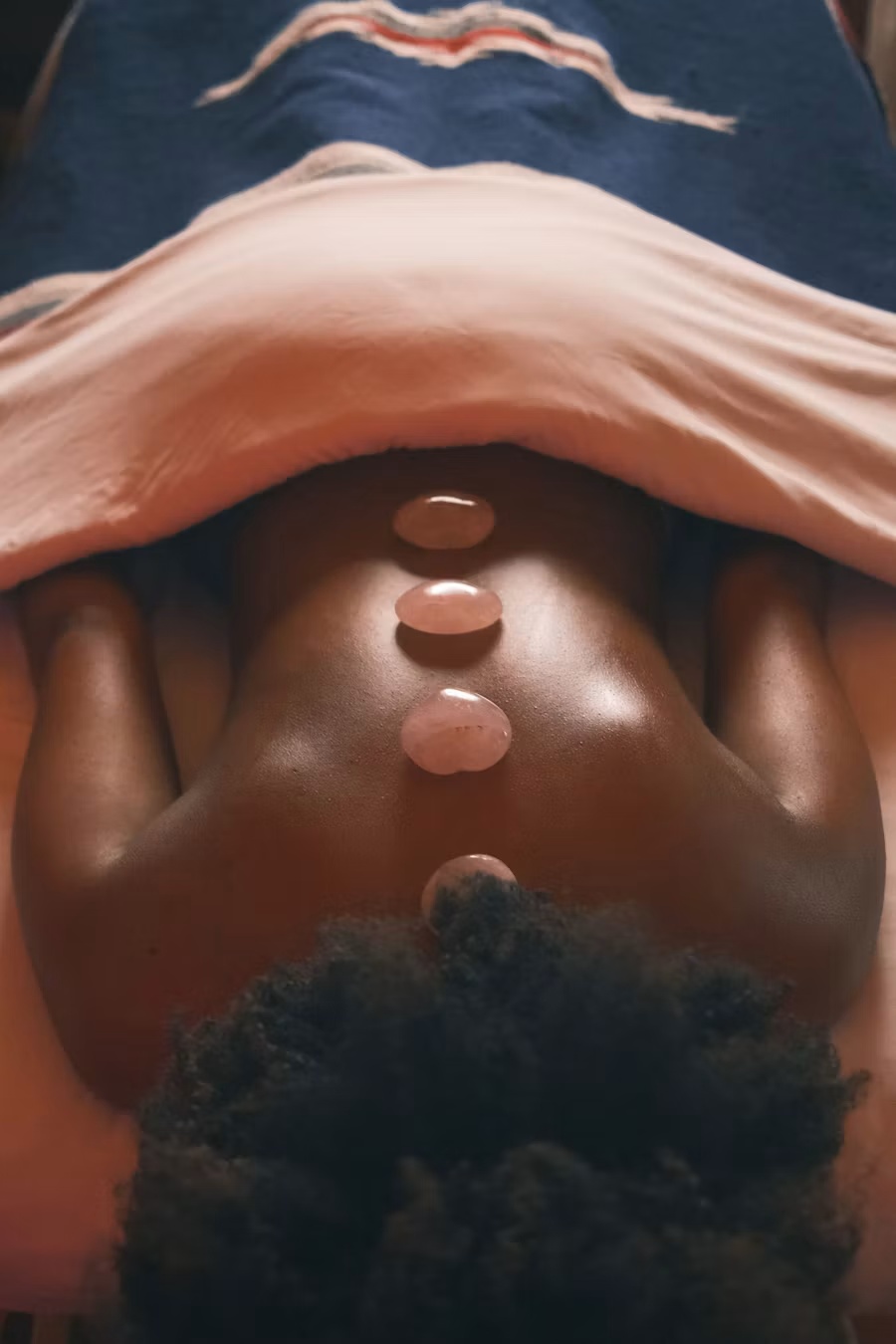 Spa stones arranged along a client’s back during a relaxing wellness treatment at Gud Vybs Spa