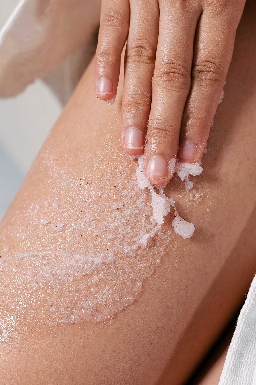 Body scrub being applied to the skin during an exfoliating spa treatment at Gud Vybs Spa