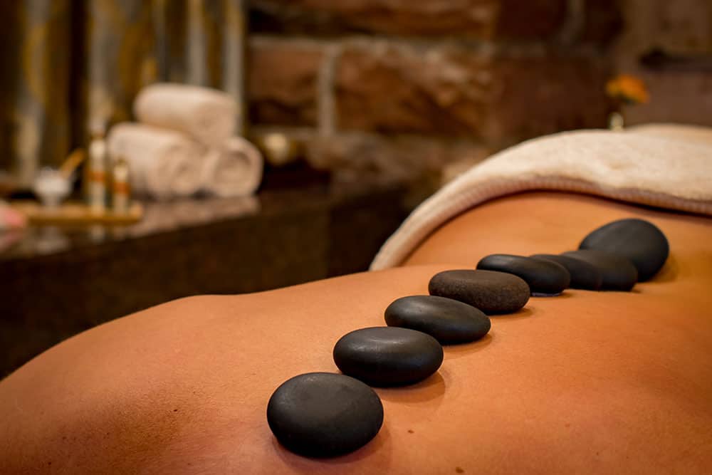 Smooth heated stones placed along a client's back during a hot stone massage